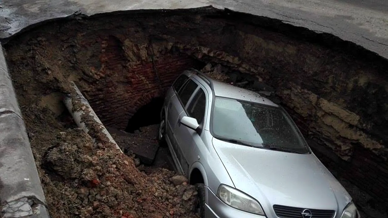 FOTO Trafic deviat în Râmnicu Sărat după ce o maşină a căzut într-o groapă formată într-o parcare