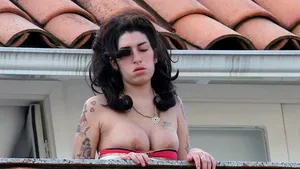 Amy Winehouse, cu privirea tulbure şi cu sânii pe afară