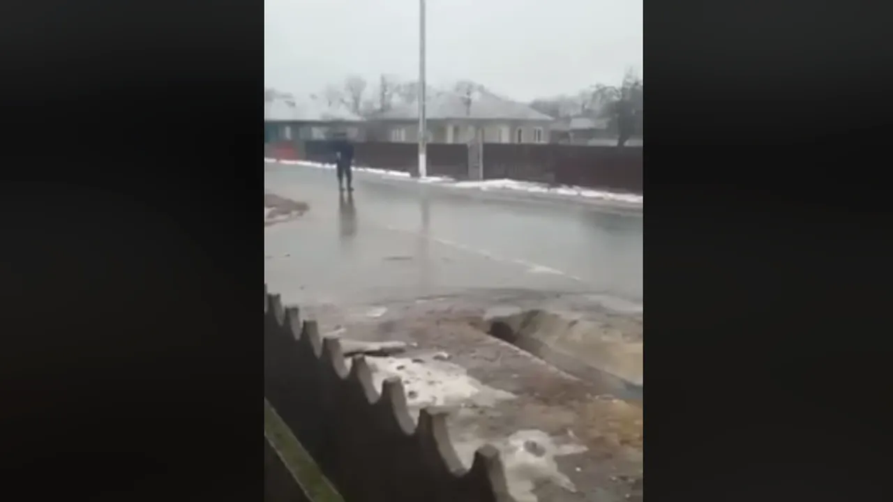 VIDEO Un ţăran, filmat în timp ce alunecă la vale, ajutat de un băţ, pe o stradă îngheţată