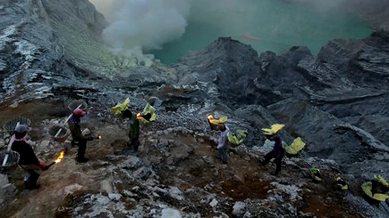 Mineri într-un vulcan activ - incredibila poveste a căutătorilor de sulf din Indonezia. Imagini cu oamenii care ignoră flăcările şi gazul toxic pentru a câştiga 10 dolari pe zi